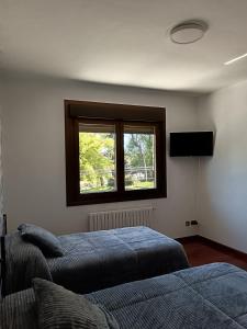 1 dormitorio con 2 camas y ventana en Casa Ruliña, en Lalín