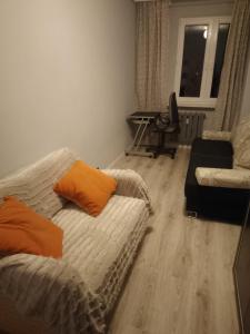 a living room with a couch and a chair at Apartament 4 in Przemyśl