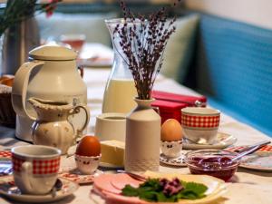 a table with eggs on plates and cups on it at Bauernhof Auerhof in Aschau im Chiemgau