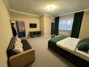 ein Hotelzimmer mit einem Bett und einem Schreibtisch in der Unterkunft Grand Bereke Hotel in Almaty