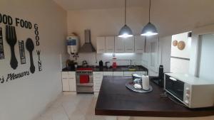una cocina con mesa y microondas. en Casa amplia y confortable, totalmente amoblada, quincho con asador, excelente ubicación, en Santiago del Estero 9 fotos más