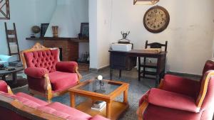 sala de estar con sofás, mesa y reloj en Casa amplia y confortable, totalmente amoblada, quincho con asador, excelente ubicación, en Santiago del Estero
