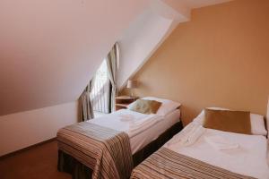Duas camas num pequeno quarto com uma janela em Hotel Bonaparte em Košice