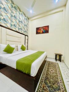 Hotel Aspiration في Tājganj: غرفة نوم بسرير وبطانية خضراء