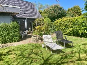 een paar stoelen in een tuin bij Haus NEDAL by fewo-plan NEUG100 an der Nordsee bei Carolinensiel-Harlesiel in Wangerland