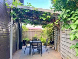 a patio with a table and chairs under a pergola at Ferienhaus NEDAL NEUG100 in Wangerland