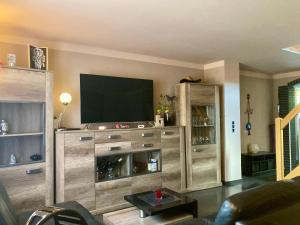 a living room with a large entertainment center with a flat screen tv at Ferienhaus NEDAL NEUG100 in Wangerland