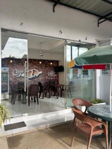 ein Restaurant mit Tischen und Stühlen in einem Glasfenster in der Unterkunft MercuryFM 101 Yarl Mercury Inn - Jaffna in Jaffna