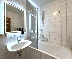 a bathroom with a sink and a shower and a tub at VALEMI BohoChic Aptmt in TopLage mit Küche&Parkplatz&Balkon in Landsberg am Lech