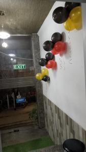 a bunch of balloons hanging on a wall at HOTEL CLINK - NEW DELHi AIRPORT in New Delhi