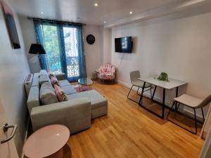 ein Wohnzimmer mit einem Sofa und einem Tisch in der Unterkunft Modern 1 bedroom apartment in town centre in Bedford