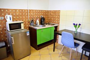 una pequeña cocina con fregadero y mesa en Makotel Apartmanház, en Makó