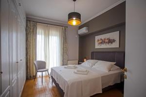 um quarto com uma cama, uma cadeira e uma janela em Socrates by Heloni Apartments em Atenas