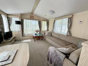 een woonkamer met een bank en een tv bij Sweet Pea Pet Friendly Lodge in South Cerney