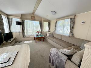 a living room with a couch and a tv at Sweet Pea Pet Friendly Lodge in South Cerney