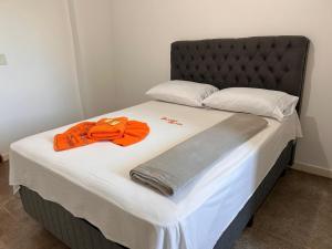 Una cama grande con toallas naranjas encima. en Dantas Hotel, en Parauapebas