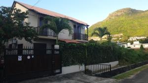 una casa con una puerta negra y una montaña en Secluded luxury villa with pool views privacy en Rivière Noire