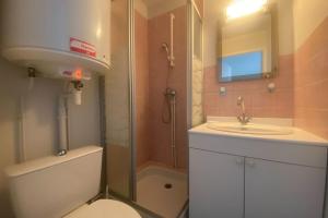 La salle de bains est pourvue de toilettes, d'un lavabo et d'une douche. dans l'établissement Cozy apartment at the foot of the beach, à Ouistreham