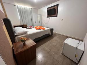 Habitación pequeña con cama y TV. en Dantas Hotel, en Parauapebas