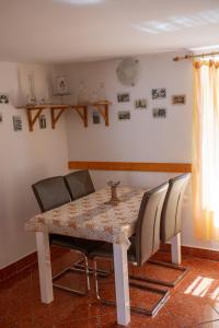 uma mesa de jantar com quatro cadeiras à volta em Európa Szíve vendégház em Tállya