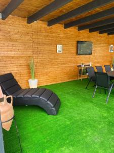 a room with black chairs and green grass at Chalet by the lake in Piatra Neamţ