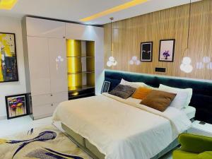 a bedroom with a large bed with a blue headboard at Austra Villa Maitama Abuja in Abuja