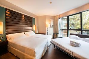 um quarto de hotel com duas camas e uma janela em Pestana Arena Barcelona em Barcelona