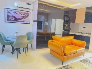 a living room with a couch and a table and a kitchen at Austra Villa Maitama Abuja in Abuja
