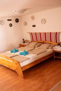 um quarto com uma cama grande e almofadas azuis em Európa Szíve vendégház em Tállya