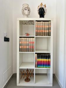 een witte boekenplank met boeken en een buste bij Flat with Terrace & Pool in Mondello