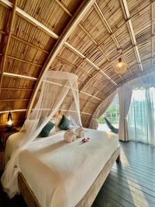 a large bed in a room with a wooden ceiling at Jaiyen Eco Resort in Ko Yao Noi