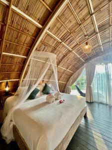 a large bed in a room with a wooden ceiling at Jaiyen Boutique Resort in Ko Yao Noi