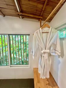 ヤオノイ島にあるJaiyen Eco Resortの窓付きの部屋に掛けられた衣