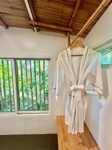 a robe hanging in a room with a window at Jaiyen Boutique Resort in Ko Yao Noi