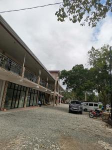 een gebouw waar auto's voor geparkeerd staan bij Buona Vita resort in Panglao