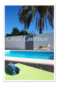 阿爾特的住宿－Casa Iantmar 2，棕榈树建筑前的游泳池
