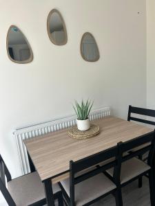 une table à manger avec deux miroirs et une plante en pot dans l'établissement Free Parking! Comfy home in Barwell, Leicester -c-, 