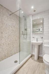 een badkamer met een douche, een toilet en een wastafel bij St Ives Hotel in Lytham St Annes