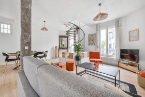 a living room with a couch and a table at Les Arômes - Maison avec jardin 8 pers Paris in Maisons-Alfort