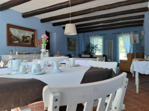 comedor con paredes azules y mesas y sillas blancas en B&B Tenuta Montegrande, en San Salvatore Monferrato
