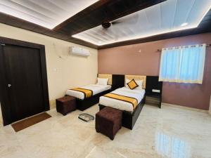 una camera con due letti, un divano e una finestra di Goroomgo Hotel Imperial Varanasi - Wonderfull Stay with Family a Varanasi