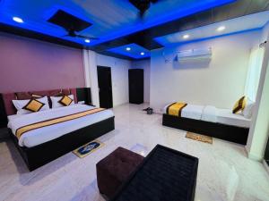 Habitación con 2 camas y sofá. en Goroomgo Hotel Imperial Varanasi - Wonderfull Stay with Family en Varanasi