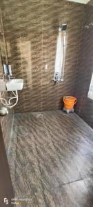 La salle de bains est pourvue d'une douche et de toilettes orange. dans l'établissement Goroomgo Hotel Imperial Varanasi - Wonderfull Stay with Family, à Varanasi