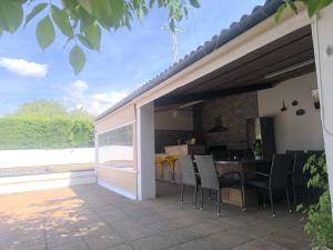 eine Terrasse mit Stühlen, einem Tisch und einer Küche in der Unterkunft Casa La Pechá, Ronda (Málaga) in Ronda