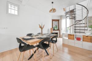 a dining room with a table and black chairs at Les Arômes - Maison avec jardin 8 pers Paris in Maisons-Alfort