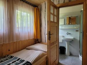a small bedroom with a bed and a sink at Domki Zacisze, Okoniny in Śliwice +65 photos