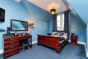 um quarto com uma cama, uma secretária e um espelho em Carlton Hotel em Forres