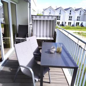 einen Tisch und Stühle auf einer Veranda mit Grill in der Unterkunft 48 1 M Seestern in Wangerland