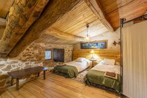 2 camas en una habitación con una pared de piedra en Les Orenetes en Artesa de Segre