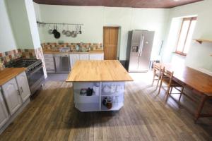 a kitchen with a wooden table and a counter top at La Vieille Ferme de la Moussiere in Saint-Jean-dʼAulps